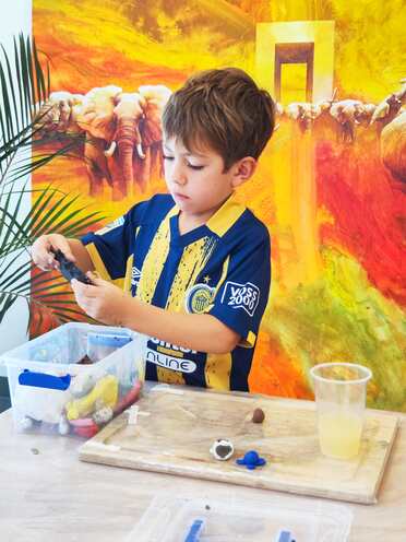 Un niño trabajando con plasticina en la mesa